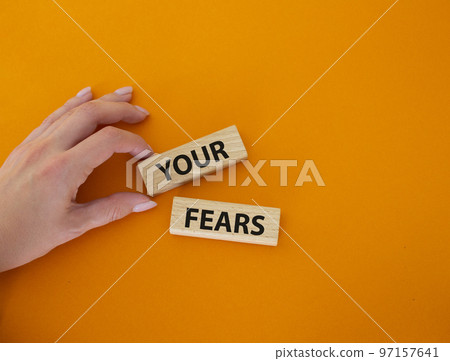 Your fears symbol. Wooden blocks with words Your fears. Beautiful orange background. Businessman hand. Business and Your fears concept. Copy space. 97157641