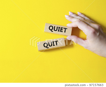 Quiet quit symbol. Concept word Quiet quit on wooden blocks. Businessman hand. Beautiful yellow background. Business and Quiet quit concept. Copy space Quiet quit symbol. Concept word Quiet quit on wooden blocks. Businessman hand. Beautiful yellow background. Business and Quiet quit concept. Copy space 97157663
