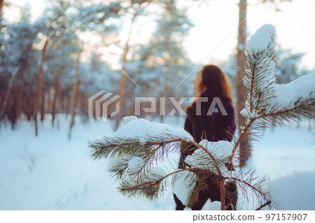 Young woman enjoying winter weather in the snow forest. 97157907