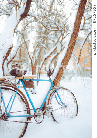 Old antique bike covered with snow in winter time Old antique bike covered with snow in winter time 97157955