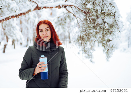 Cheerful girl in warm clothes playing with snow outdoors near the beautiful forest Cheerful girl in warm clothes playing with snow outdoors near the beautiful forest 97158061
