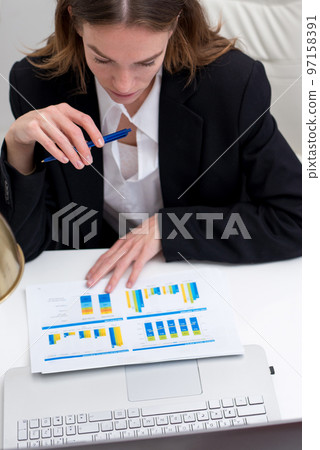 Woman works with documents and studies statistical data 97158391