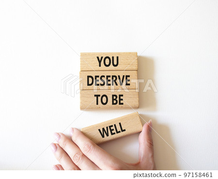You deserve to be well symbol. Wooden blocks with words You deserve to be well. Beautiful white background. Businessman hand. You deserve to be well concept. Copy space. 97158461