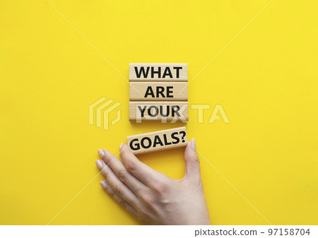 Goals symbol. Concept words What are your goals on wooden blocks. Beautiful yellow background. Businessman hand. Business and What are your goals concept. Copy space. 97158704
