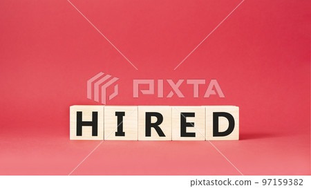 Hired symbol. Wooden cubes with word Hired. Beautiful red background. Hired concept. Copy space. 97159382