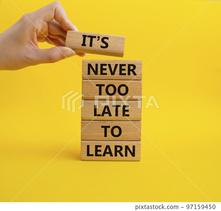 It's Never to Late to Learn symbol. Wooden blocks with words It's Never to Late to Learn. Beautiful yellow background. Businessman hand. Business and It's Never to Late to Learn. Copy space. 97159450