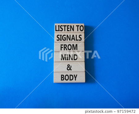 Body and mind wellness symbol. Concept words Listen to signals from mind and body on wooden blocks. Beautiful blue background. Medical and mental or physical health concept. Copy space. 97159472