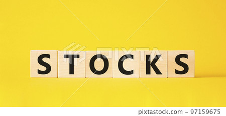 Stocks symbol. Concept word Stocks on wooden cubes. Beautiful yellow background. Business and Stocks concept. Copy space. 97159675