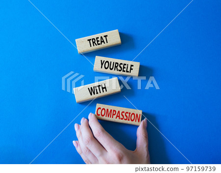 Treat yourself with compassion symbol. Concept words Treat yourself with compassion on wooden blocks. Beautiful blue background. Doctor hand. Medicine concept. Copy space. 97159739