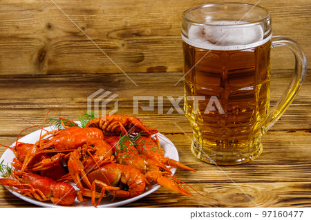 Boiled crayfish and mug of beer on a wooden table 97160477