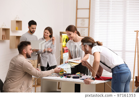 Fashion designers creating new clothes in studio Fashion designers creating new clothes in studio 97161353