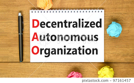 DAO decentralized autonomous organization symbol. Concept words DAO decentralized autonomous organization on white note on a beautiful wooden background. Business and DAO concept. Copy space. DAO decentralized autonomous organization symbol. Concept words DAO decentralized autonomous organization on white note on a beautiful wooden background. Business and DAO concept. Copy space. 97161457