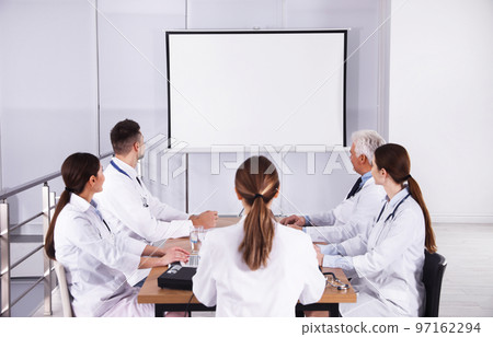 Team of doctors using video projector during conference indoors 97162294