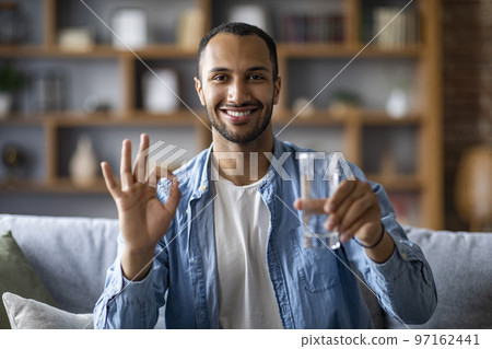 Cheerful Handsome Black Guy Holding Glass Of Water And Showing Ok Gesture 97162441