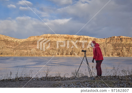 senior male photographer with a camera on tripod senior male photographer with a camera on tripod 97162807