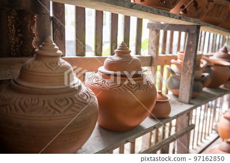 Handicraft clay pot on wooden shelf in natural light in Koh Kred Handicraft clay pot on wooden shelf in natural light in Koh Kred 97162850