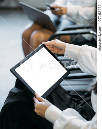 Online communication. Digital mockup. Virtual conference. Female hands holding tablet computer with blank screen sitting light room interior. 97162932