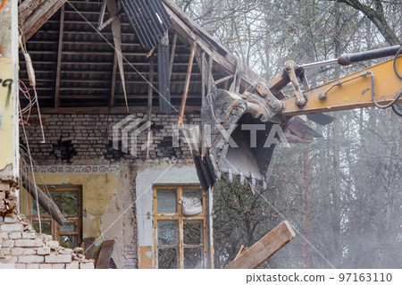 Demolition of an old brick building with an excavator bucket Demolition of an old brick building with an excavator bucket 97163110
