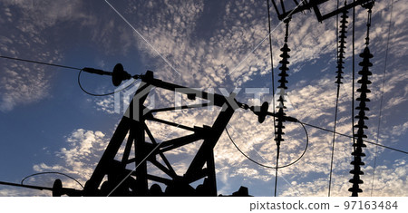 Electricity pylon (high voltage power line), black contour,  against the background of a romantic evening sky 97163484