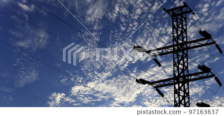 Electricity pylon (high voltage power line), black contour,  on the background of the cloudy sky 97163637