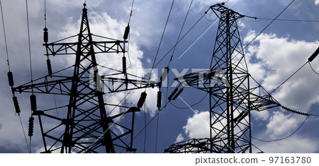 Electricity pylon (high voltage power line), black contour,  on the background of the cloudy sky 97163780