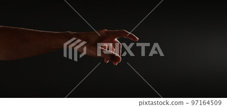 hand reaches for the light on a black background 97164509