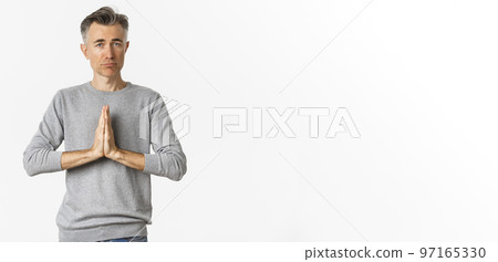 Image of sad middle-aged man begging for help, need something and asking for favour, standing over white background Image of sad middle-aged man begging for help, need something and asking for favour, standing over white background 97165330