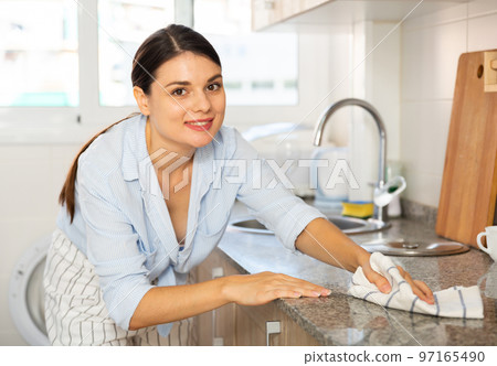 Woman cleaning kitchen after cooking 97165490