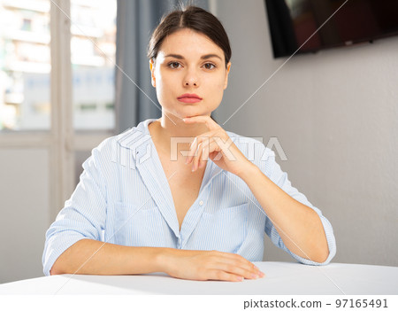 Upset young woman sitting at table 97165491