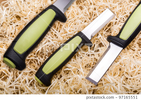 Woodworking tool. Carpentry tool. Sharp chisel and wood shavings. Wood cutting tool. Knife chisel in three angles. Woodworking tool. Carpentry tool. Sharp chisel and wood shavings. Wood cutting tool. Knife chisel in three angles. 97165551