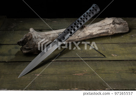 Large and narrow knife. Knife with double sharpened blade. Knife on a wooden stick. Large and narrow knife. Knife with double sharpened blade. Knife on a wooden stick. 97165557
