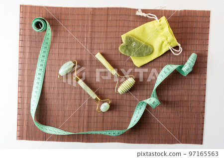 Soft meter and massage stones. Control of volume and completeness. Meter and stones on a bamboo mat. 97165563