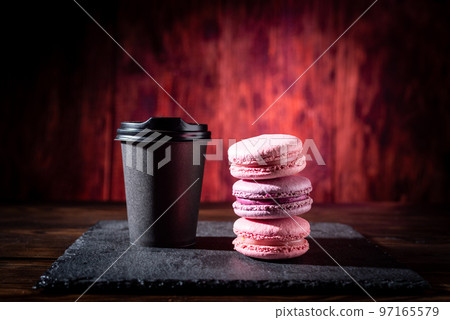 Glass of coffee and cookies. Black glass and red cookies. Black coffee and French biscuits. Macaroon cookies. 97165579
