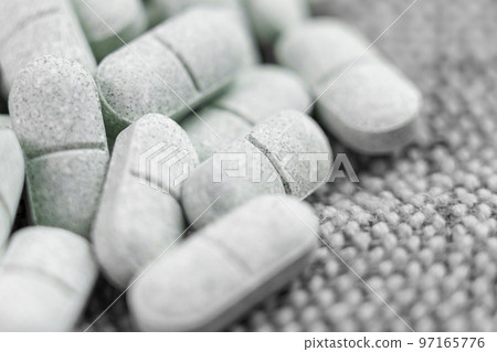 Tryptophan sedative pills on rough cloth. Remedy for depression and insomnia. Natural pharmaceutical antidepressant Tryptophan sedative pills on rough cloth. Remedy for depression and insomnia. Natural pharmaceutical antidepressant 97165776