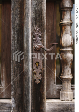 Antique wooden ornamental door with elegant iron handle close up Antique wooden ornamental door with elegant iron handle close up 97165788