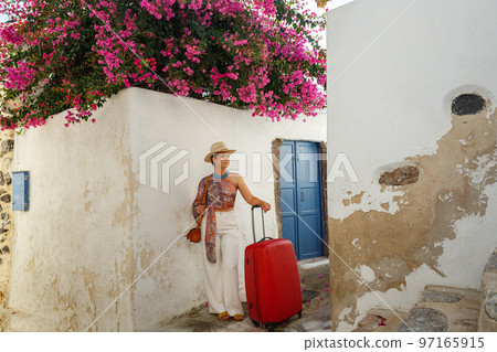 Young woman with a red suitcase in island Santorini Young woman with a red suitcase in island Santorini 97165915