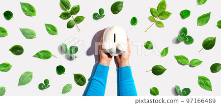 Person holding a piggy bank with green leaves 97166489