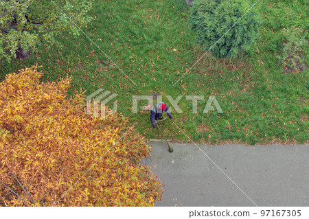 worker mows the grass with a gasoline brushcutter worker mows the grass with a gasoline brushcutter 97167305