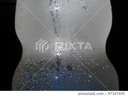 Cold surface of gas water bottle with sparkling bubbles macro shot Cold surface of gas water bottle with sparkling bubbles macro shot 97167445