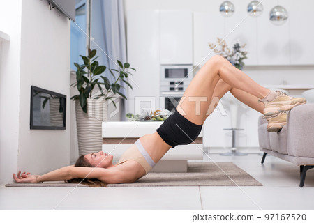 Fit woman doing exercise glute bridge at home. 97167520