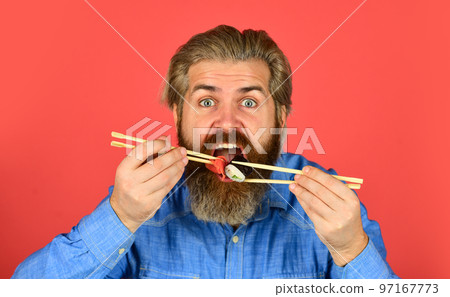 Sushi rolls. Japanese cuisine. Asian meal. Sushi roll. Man eat sushi chopsticks. Eastern culture. Bearded hipster eating rolls. Japanese food delivery. Pickled ginger served with sushi or sashimi Sushi rolls. Japanese cuisine. Asian meal. Sushi roll. Man eat sushi chopsticks. Eastern culture. Bearded hipster eating rolls. Japanese food delivery. Pickled ginger served with sushi or sashimi 97167773