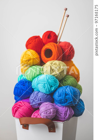 Lots of bright, colorful yarns for knitting and crochet in a stylish scandi style basket. Cozy homely atmosphere. 97168175
