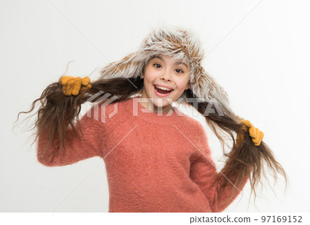 not spoiling your woolly sweater. cold winter weather. warm clothes and accessory fashion for kid. happy childhood. small girl in fur earflap hat and gloves. xmas holiday activity. child cosy sweater 97169152