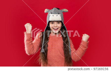 successful teen child model in earflap hat. teen child in earflap hat isolated on red background. 97169156