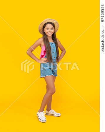 teen girl smile in straw hat standing on yellow background 97169538