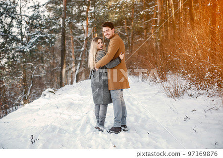 happy young couple walking through the park on a snowy day 97169876