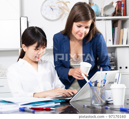 Two businesswomen working with computer in office Two businesswomen working with computer in office 97170160
