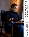he girl looks at her laptop and makes notes in a notebook 97170547