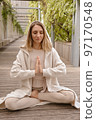 A woman meditates in the park 97170548