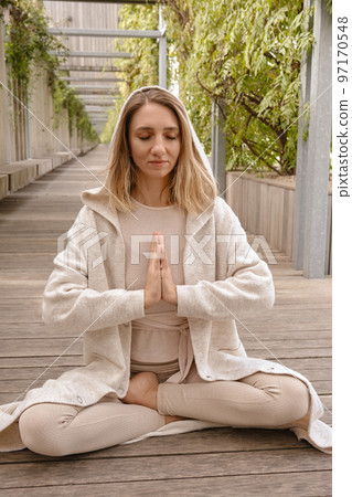 A woman meditates in the park A woman meditates in the park 97170548
